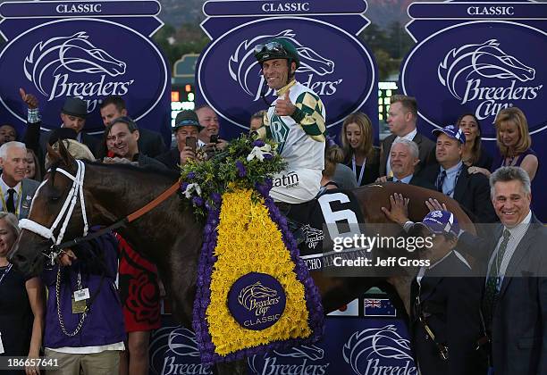 Jockey Gary Stevens celebrates atop Mucho Macho Man in the winner's circle after winning the Classic during the 2013 Breeders' Cup World...