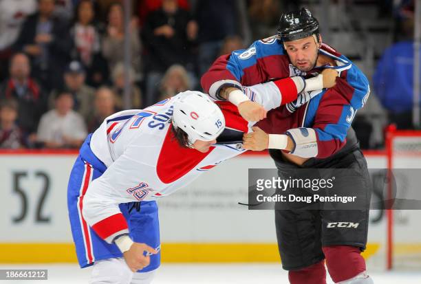 George Parros of the Montreal Canadiens and Patrick Bordeleau of the Colorado Avalanche engage in a fight in the first period at Pepsi Center on...