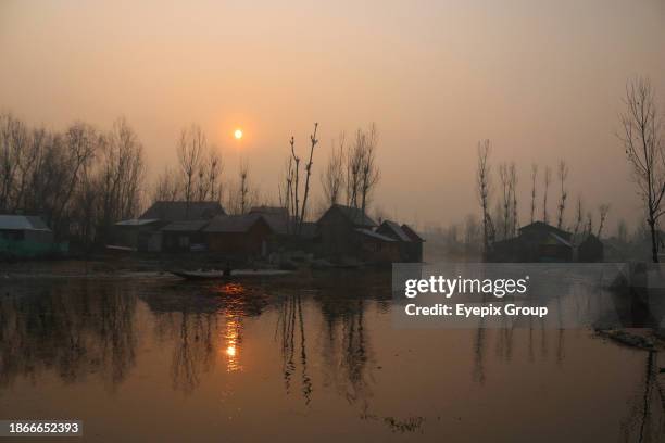 December 21 Srinagar Kashmir, India : A man rows a boat on the waters of dal lake in Srinagar. The 40 day harshest winter period 'Chillai-Kalan',...