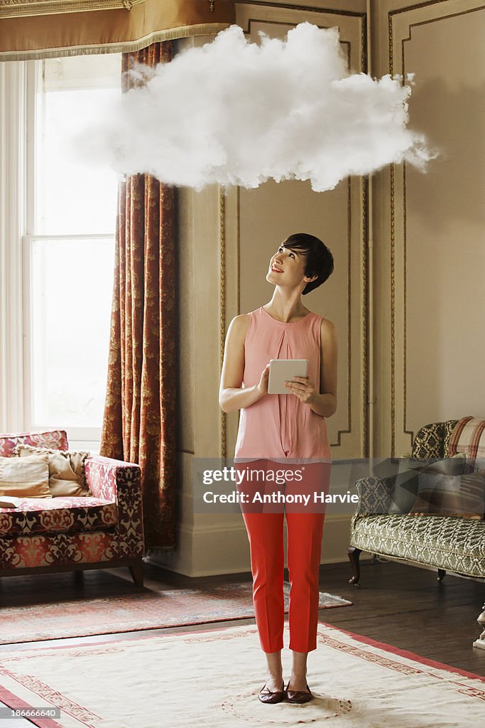 Woman in living room looking at cloud above head