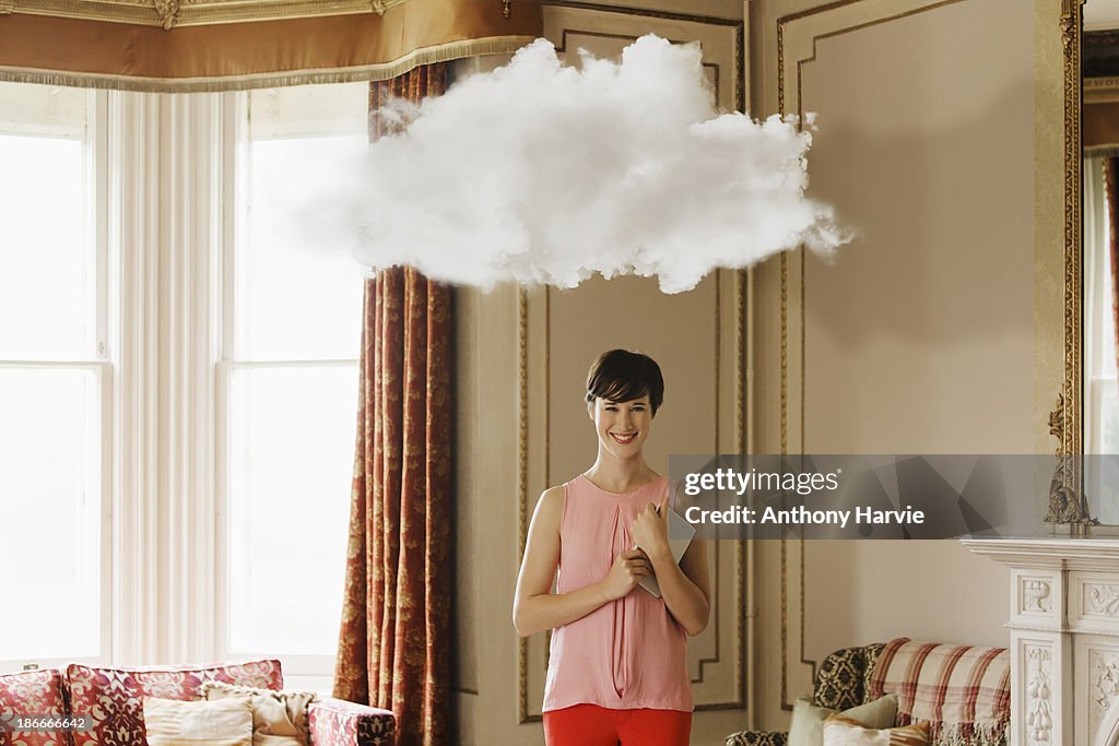 Smiling woman in living room with cloud above head