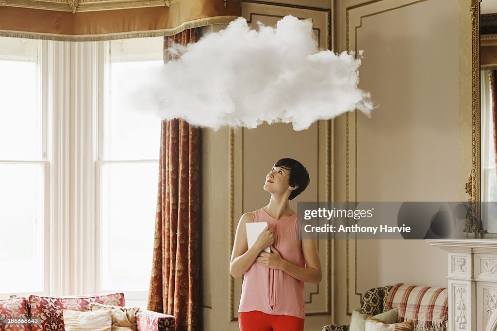 Woman in living room looking at cloud above head