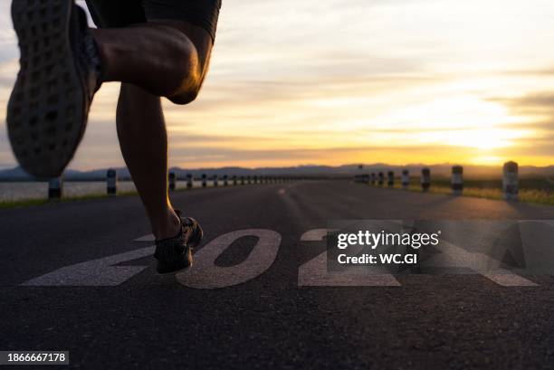 sportsperson is sprinting on the road with the text new year 2024 concept. - sport determination stock-fotos und bilder