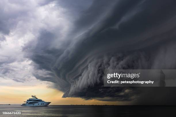 yate de lujo bajo una "nube de plataforma" tropical de aspecto aterrador - embarcación-marina fotografías e imágenes de stock