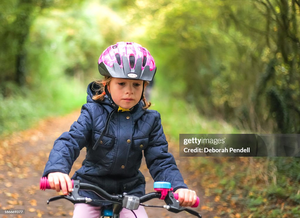Young girl on a bicycle wearing safety helmet