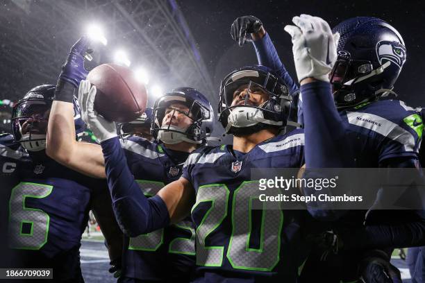 Julian Love of the Seattle Seahawks celebrates with teammates after an interception in the fourth quarter at Lumen Field on December 18, 2023 in...