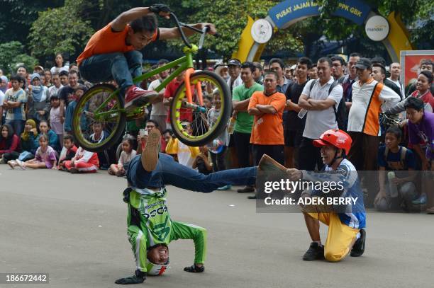 Members of Double B cycling community Indonesian Trisno , Apen and Budi Raharjo perform a cycling stunt at the Gelora Bung Karno sport center in...