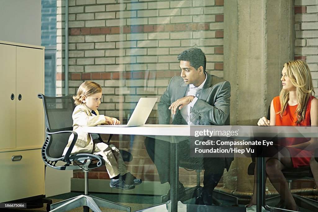 Boy (3-5) chairing business meeting