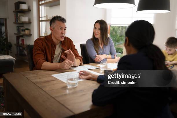 couple talking with financial advisor - family converse stock pictures, royalty-free photos & images