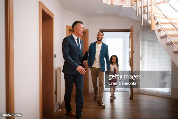 real estate agent showing house to family - family front door stock pictures, royalty-free photos & images