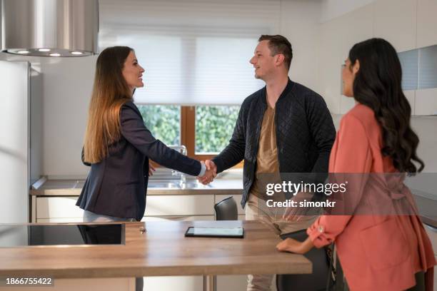 real estate agent shaking hand with couple - easy access stock pictures, royalty-free photos & images