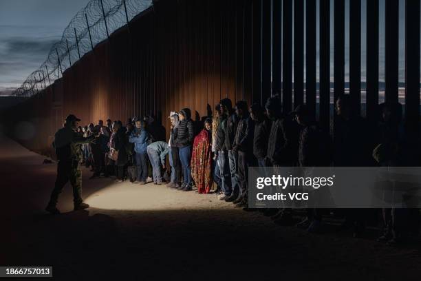 Asylum-seeking migrants wait to be processed by the U.S. Border Patrol after crossing the nearby border with Mexico near the Jacumba Hot Springs on...