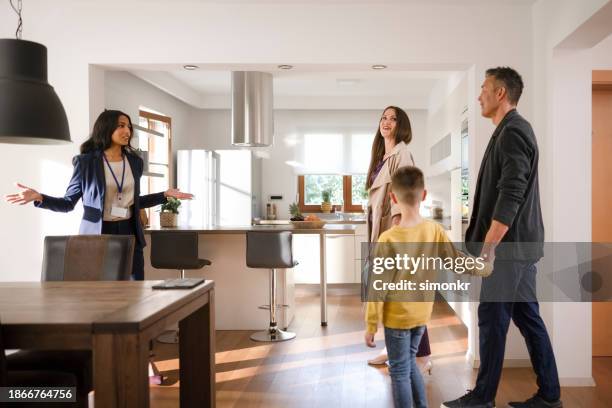 real estate agent showing house to family - luxury home dining table people lifestyle photography people stock pictures, royalty-free photos & images