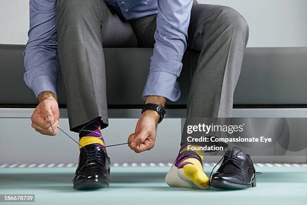 man tying shoe laces - lace trousers stockfoto's en -beelden