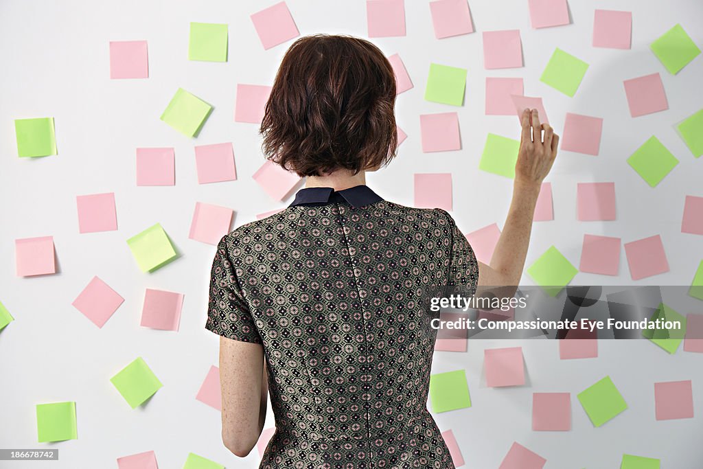 Woman placing sticky notes on board