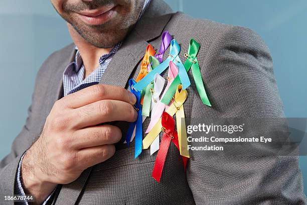 man with charity ribbons on lapel - charitable foundation stockfoto's en -beelden