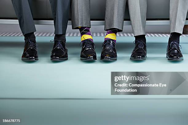 three men sitting on bench, view of shows - individuality photos et images de collection