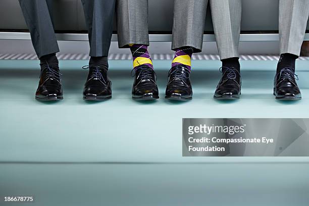 three men sitting on bench, view of shows - business shoes stockfoto's en -beelden