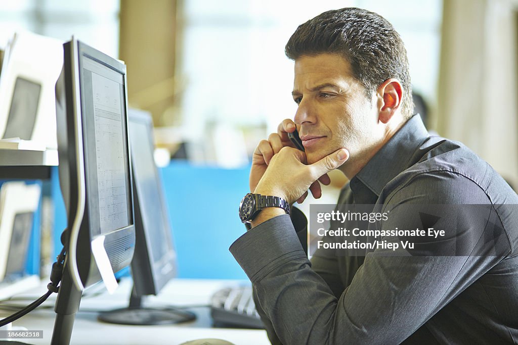 Man Watching Computer Man Sitting At Desk Looking At Computer Monitor High-Res Stock Photo ...