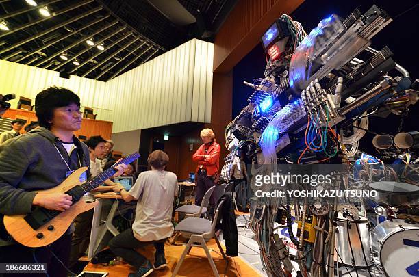 Man plays an electric guitar to control robot guitarist "Mach", a member of a robot rock band "Z-Machines", during the two day art and technology...