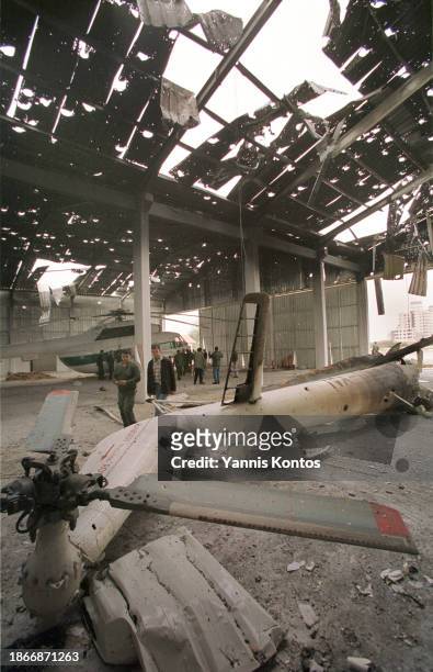 Palestinians inspect destroyed helicopters in a hangar with a roof shattered by heavy machine gun bullets and missiles in Gaza City on December 4,...