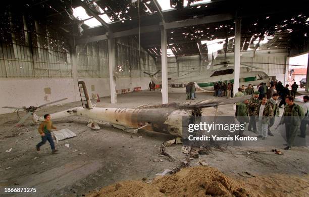 Palestinians inspect destroyed helicopters in a hangar with a roof shattered by heavy machine gun bullets and missiles in Gaza City on December 4,...