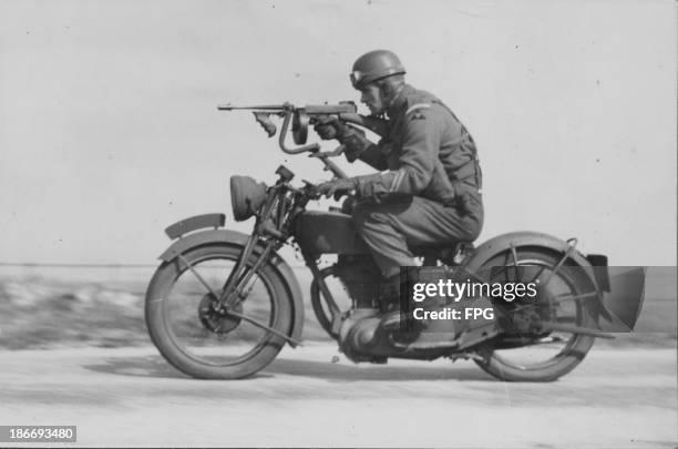 British soldier of the Grenadier Guards Regiment, riding a Tommy gun motorbike, England, circa 1914-1919.