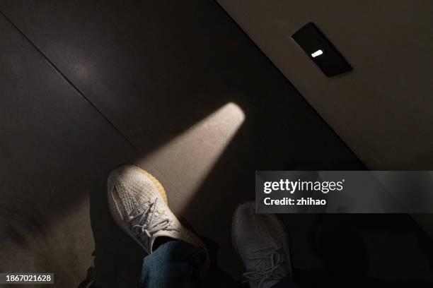 the night lights in the hallway illuminate the shoes of pedestrians - infrared lamp stockfoto's en -beelden