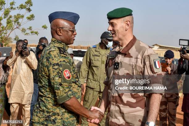 General Eric Ozanne , commander of French forces in the Sahel chakes hands with the Chief of staff of the Armies of Togo , mediating in the process...