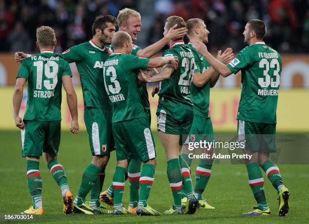 Andre Hahn of FC Augsburg is congratulated by his team mates after scoring during the Bundesliga match between FC Augsburg v 1. And FSV Mainz 05 at...