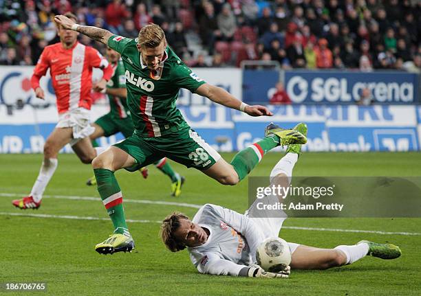 Andre Hahn of FC Augsburg jumps over goalkeeper Christian Wetklo of FSV Mainz during the Bundesliga match between FC Augsburg v 1. And FSV Mainz 05...