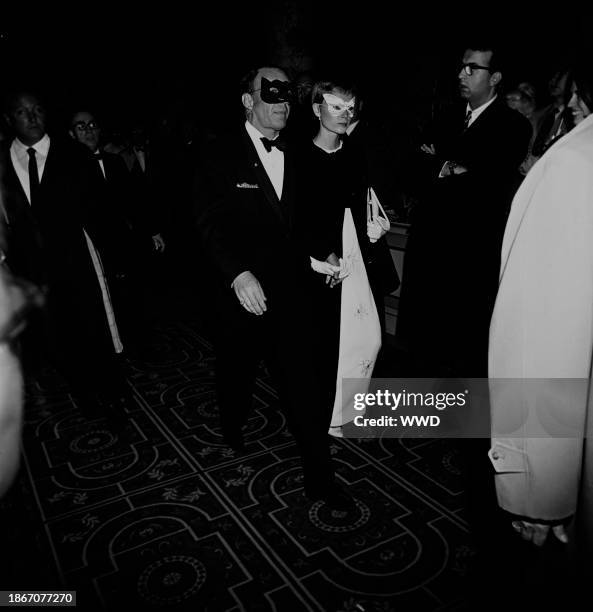 Singer Frank Sinatra and actress Mia Farrow, both masked, arriving at Truman Capote's Black and White Ball in the Grand Ballroom at the Plaza Hotel...