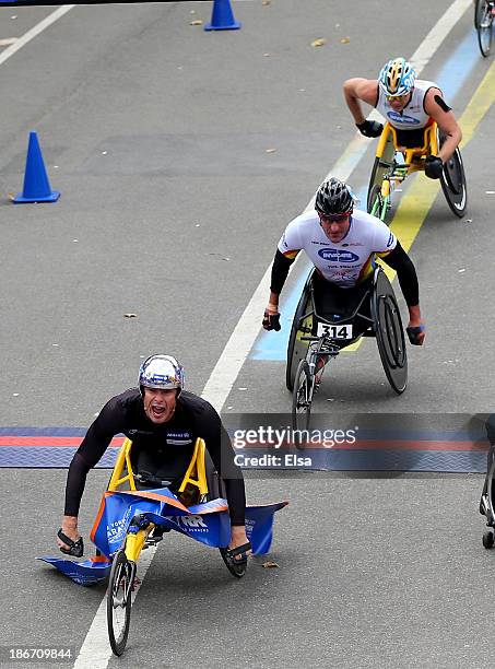 Marcel Hug of Switzerland leads the pack as Ernst Van Dyk of South Africa and Kurt Fearnley of Australia cross the finish line in the Mens Wheelchair...