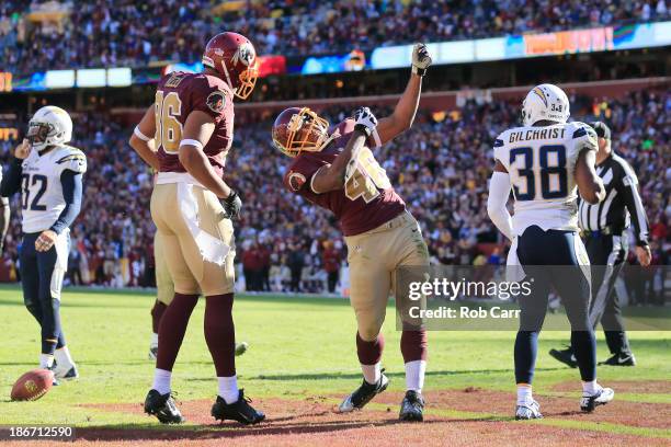 Marcus Gilchrist of the San Diego Chargers looks on as running back Alfred Morris of the Washington Redskins celebrates with teammate Jordan Reed...