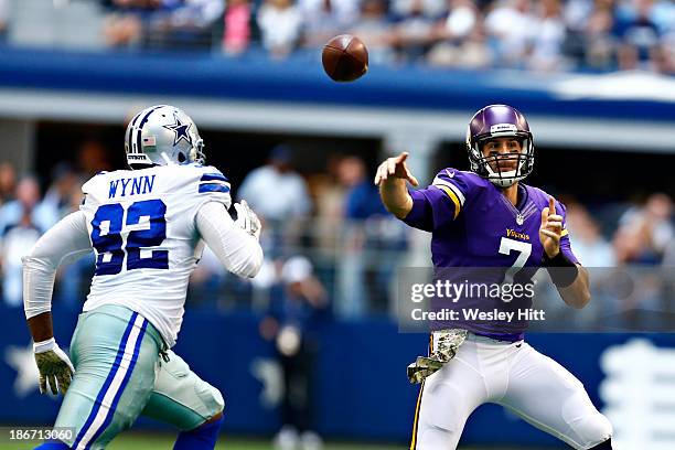 Christian Ponder of the Minnesota Vikings throws a pass under pressure from Jarius Wynn of the Dallas Cowboys at AT&T Stadium on November 3, 2013 in...