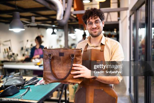 kaukasischer männlicher schneider mit brauner ledertasche, die er gemacht hat - ledertasche stock-fotos und bilder