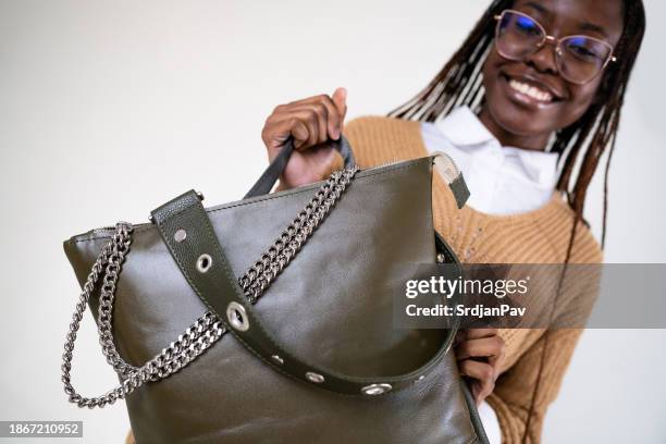 female fashion model black ethnicity, carrying an black leather bag - black purse stock pictures, royalty-free photos & images