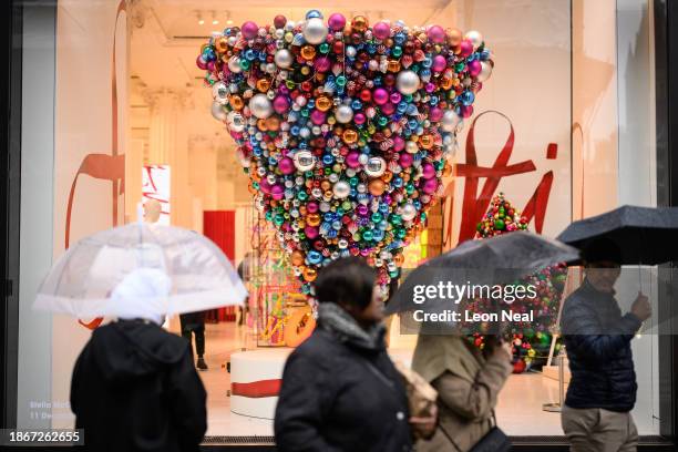 An inverted Christmas tree window display is seen as shoppers walk in the Oxford Street retail district on December 19, 2023 in London, England. A...