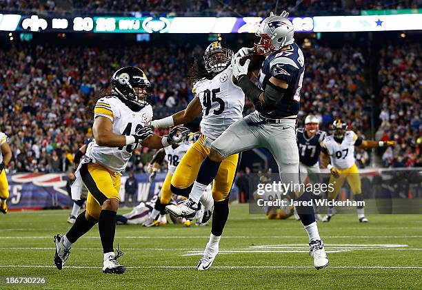 Rob Gronkowski of the New England Patriots catches a pass in front of Jarvis Jones and Troy Polamalu of the Pittsburgh Steelers in the second quarter...