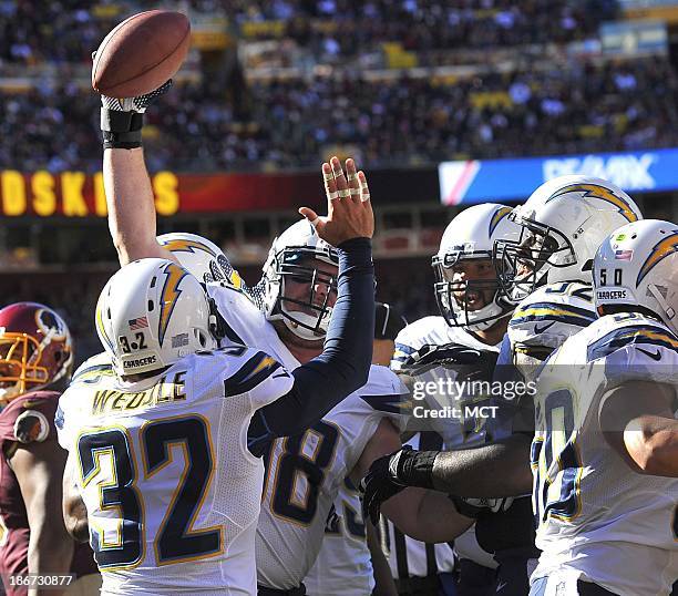 San Diego Chargers defensive end Sean Lissemore celebrates with teammates after catching a tipped pass in the end zone for a touchdown against the...