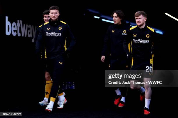 Matt Doherty, Fabio Silva and Matt Doherty of Wolverhampton Wanderers make their way out for warm ups ahead of the Premier League match between West...