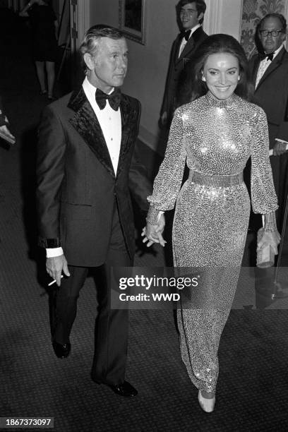 Johnny Carson, wearing a velvet trimmed tuxedo, with new wife Joanna Carson at a party celebrating his tenth year of hosting The Tonight Show