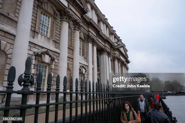 People walk along the path on the bank of the River Thames past the Queen Anne Court, University of Greenwich on December 16, 2023 in London, United...