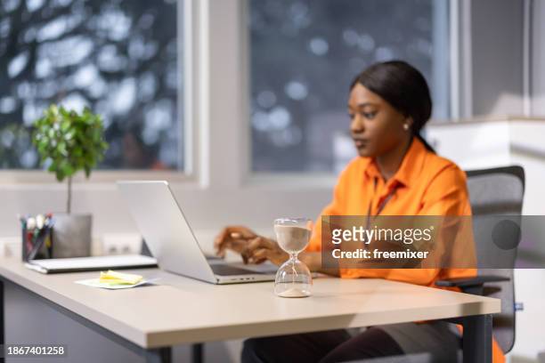 ambitious businesswoman working in office - clock person desk stockfoto's en -beelden