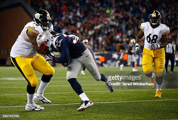 Duron Harmon of the New England Patriots runs with an intercepted pass in the fourth quarter while being tackled by Guy Whimper of the Pittsburgh...