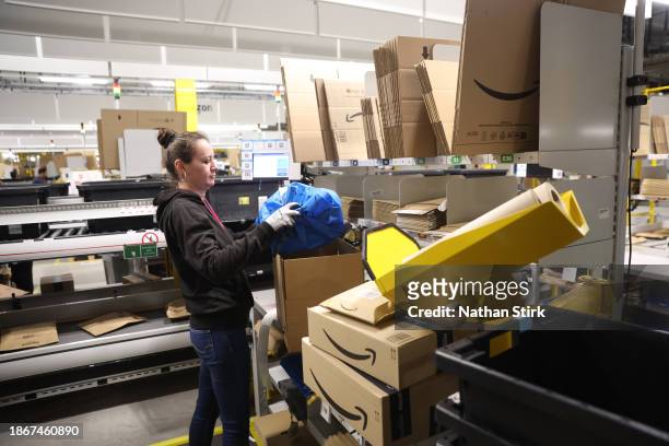 An Amazon employee packs items at Amazon's Robotic Fulfillment Centre on December 19, 2023 in Sutton Coldfield, England. Launched in October, the...