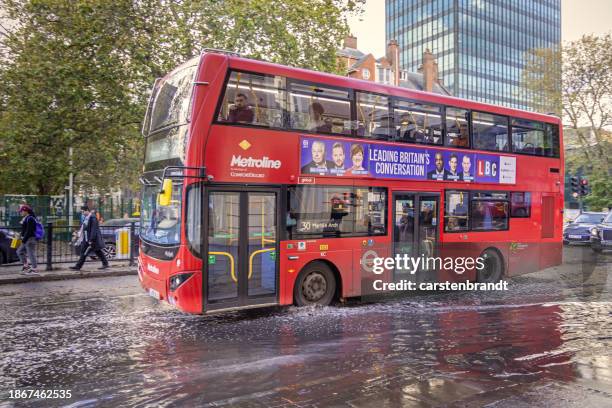 london double-decker bus in front of a large puddle - bus side view stock pictures, royalty-free photos & images