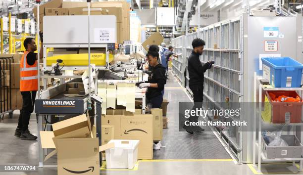 Amazon employees pack items at Amazon's Robotic Fulfillment Centre on December 19, 2023 in Sutton Coldfield, England. Launched in October, the 24/7...
