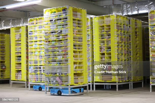 Robot brings a pallet of items to employees for sorting at Amazon's Robotic Fulfillment Centre on December 19, 2023 in Sutton Coldfield, England....