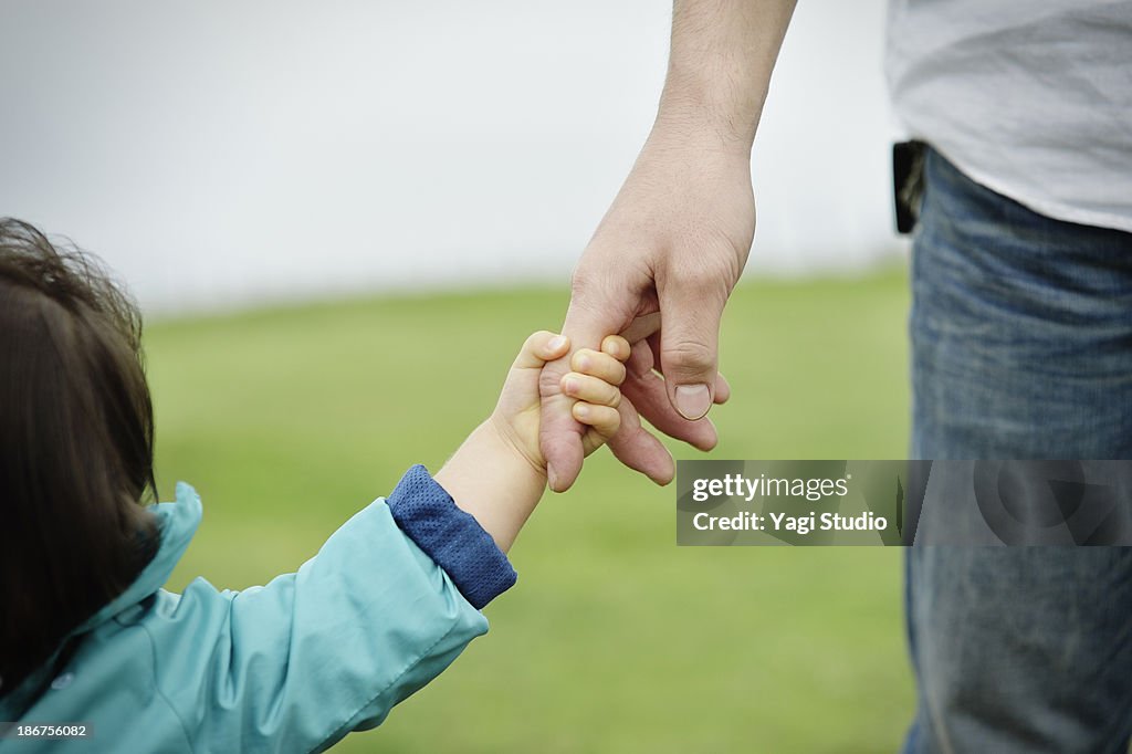 Father and daughter holding hands